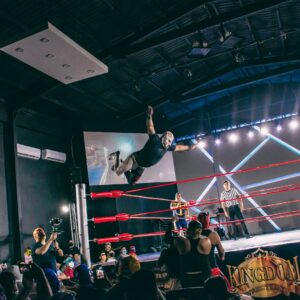 a person doing a stunt on a stage with a crowd watching